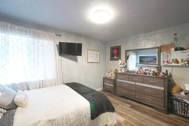 bedroom featuring a textured ceiling and light wood-type flooring