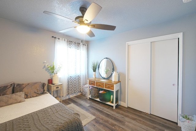 bedroom featuring dark hardwood / wood-style flooring, a closet, a textured ceiling, and ceiling fan