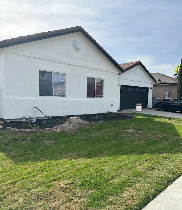 view of side of home featuring a yard and a garage