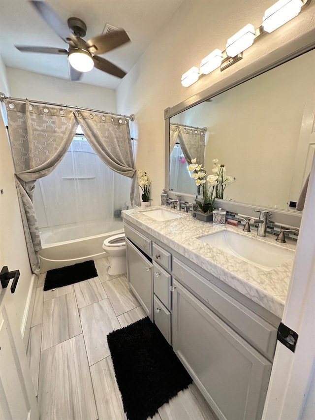 full bathroom with vanity, shower / tub combo with curtain, toilet, and ceiling fan