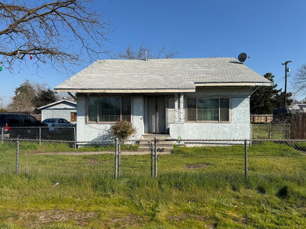 bungalow-style home with a front yard