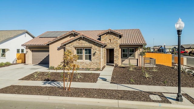 mediterranean / spanish-style home featuring solar panels and a garage