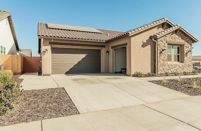 view of front of home featuring a garage and solar panels