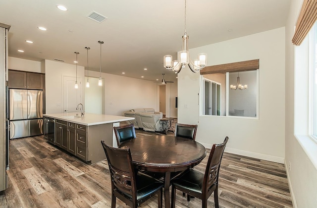 dining space featuring sink, dark hardwood / wood-style flooring, plenty of natural light, and an inviting chandelier