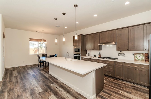 kitchen featuring sink, appliances with stainless steel finishes, dark hardwood / wood-style flooring, and hanging light fixtures