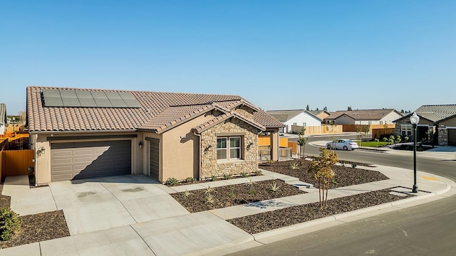 view of front of home featuring solar panels and a garage