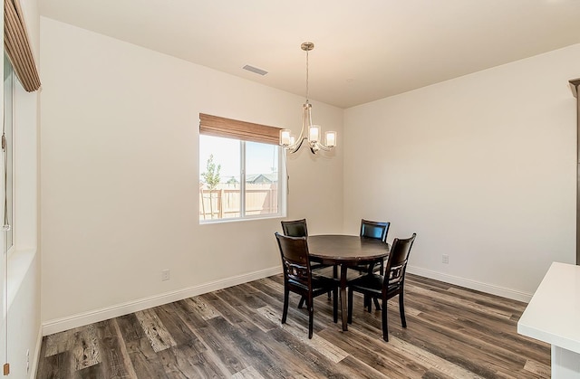 dining room featuring dark wood-type flooring and an inviting chandelier