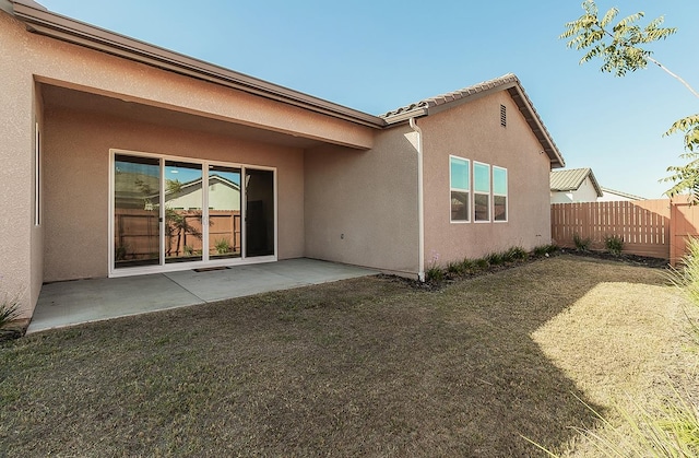 rear view of property featuring a patio and a yard