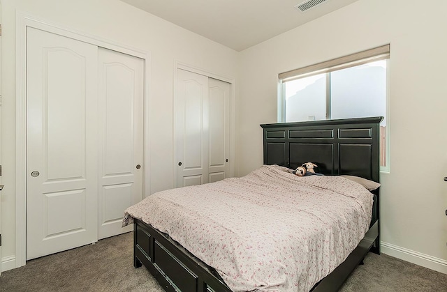 bedroom featuring carpet floors and multiple closets