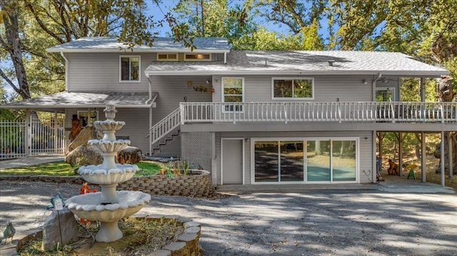 rear view of property with a deck and a patio area