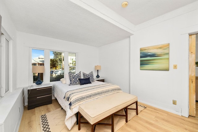 bedroom with light hardwood / wood-style flooring and a textured ceiling