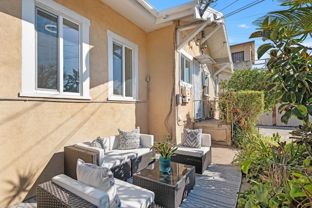 wooden terrace featuring an outdoor hangout area and a patio