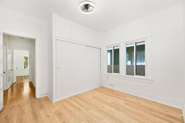 spare room featuring light hardwood / wood-style flooring and a textured ceiling