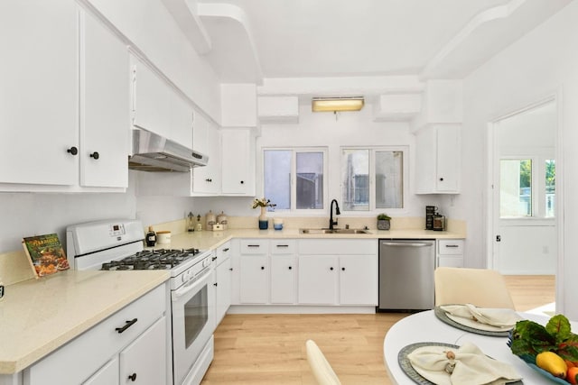 kitchen with gas range gas stove, light hardwood / wood-style floors, stainless steel dishwasher, white cabinets, and exhaust hood