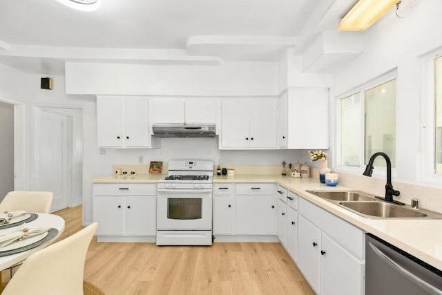 kitchen with sink, light wood-type flooring, white gas range oven, stainless steel dishwasher, and white cabinets