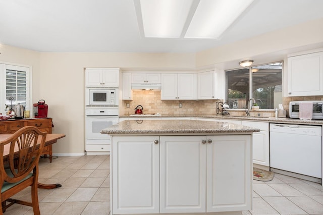 kitchen with white cabinets, white appliances, and a kitchen island