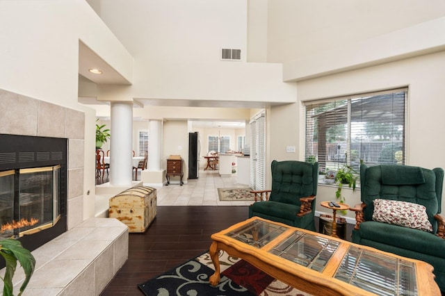 living room featuring a tiled fireplace and light hardwood / wood-style flooring