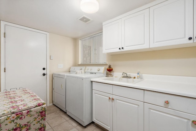 clothes washing area with sink, light tile patterned floors, cabinets, and independent washer and dryer