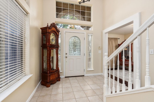 tiled entrance foyer featuring a towering ceiling