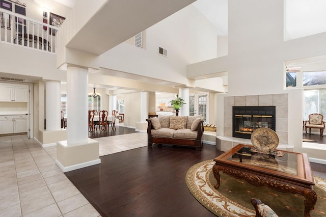 living room featuring light tile patterned flooring, a fireplace, and high vaulted ceiling