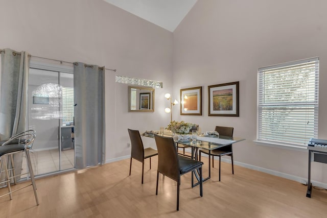 dining room featuring light hardwood / wood-style floors and high vaulted ceiling