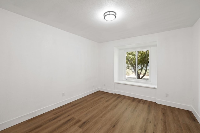 spare room featuring a textured ceiling and hardwood / wood-style flooring