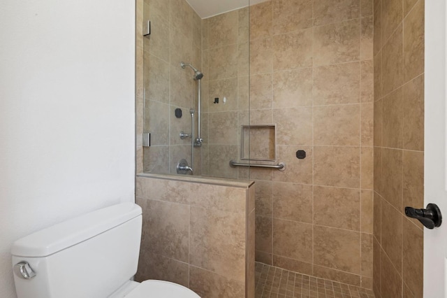 bathroom featuring a tile shower and toilet