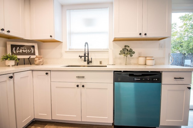 kitchen featuring stainless steel dishwasher, sink, white cabinetry, and a wealth of natural light