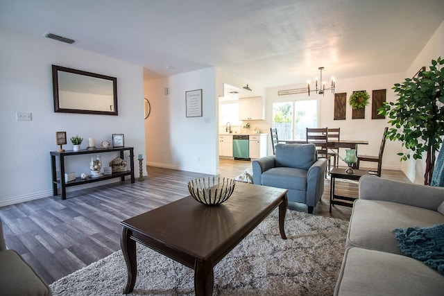 living room featuring sink, hardwood / wood-style floors, and a chandelier