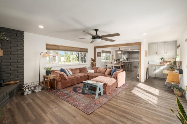 living room featuring dark wood-type flooring and ceiling fan