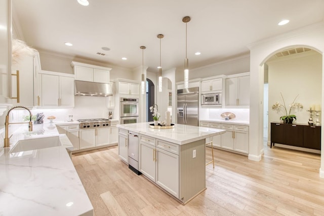 kitchen featuring sink, a kitchen island, built in appliances, and light hardwood / wood-style floors