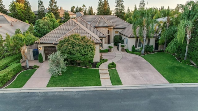 mediterranean / spanish-style home featuring a front yard and a garage