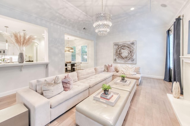 living room with an inviting chandelier, light hardwood / wood-style flooring, and ornamental molding