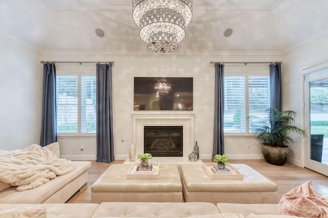 living room featuring crown molding, a healthy amount of sunlight, and light wood-type flooring