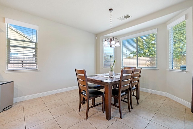 dining space with a notable chandelier and light tile patterned floors