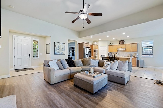 living room featuring ceiling fan, light hardwood / wood-style floors, and plenty of natural light