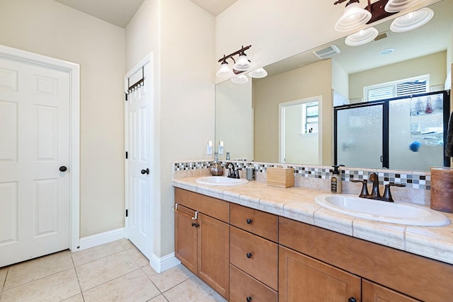 bathroom with vanity, tasteful backsplash, walk in shower, and tile patterned floors