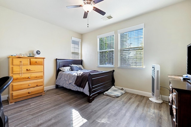 bedroom with dark hardwood / wood-style flooring and ceiling fan