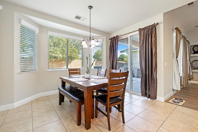 dining area featuring light tile patterned floors and an inviting chandelier