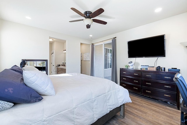 bedroom with ensuite bathroom, hardwood / wood-style flooring, and ceiling fan