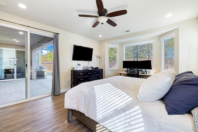 bedroom featuring access to exterior, hardwood / wood-style flooring, multiple windows, and ceiling fan