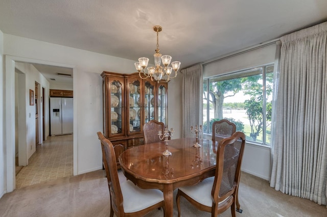 dining room with a notable chandelier and light colored carpet