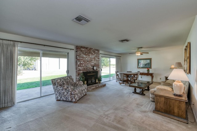 living room featuring light colored carpet, ceiling fan, and a fireplace