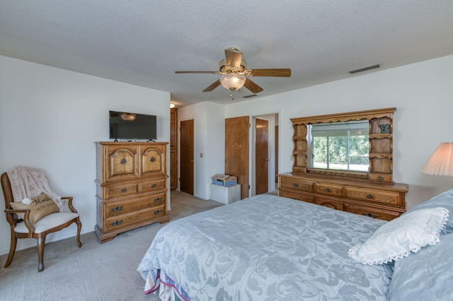 carpeted bedroom featuring a textured ceiling and ceiling fan