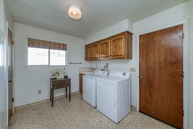 laundry area with washing machine and dryer and cabinets