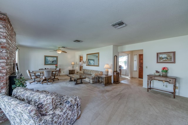 living room with light carpet, a textured ceiling, and ceiling fan