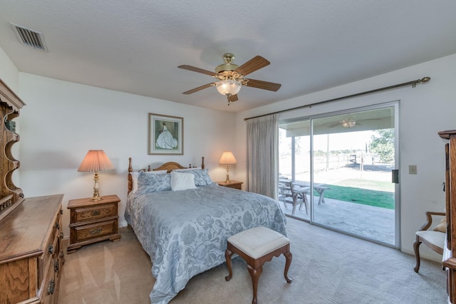 bedroom with ceiling fan, light carpet, a textured ceiling, and access to exterior