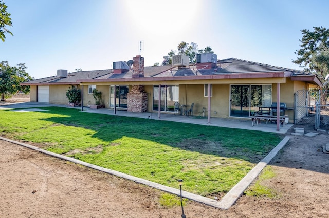 back of house featuring a patio and a lawn