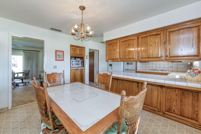 dining space with light carpet and an inviting chandelier