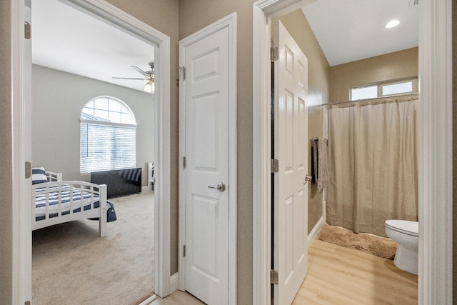 bathroom featuring curtained shower, wood-type flooring, toilet, and ceiling fan